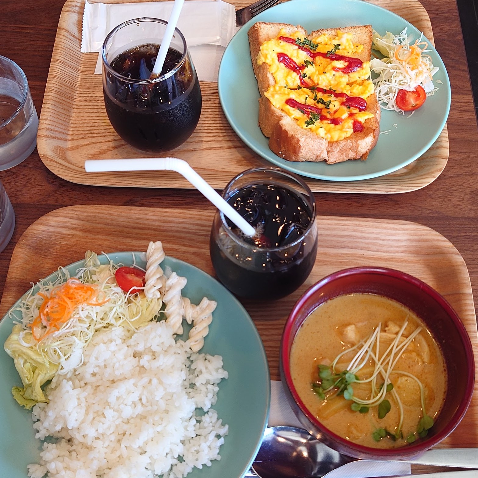 木製トレイにのったハムチーズトーストとアイスコーヒーのグラス、小皿の漬物